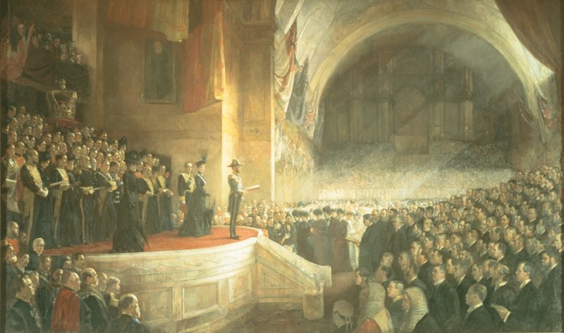 A painting of a man wearing a formal hat and uniform standing and speaking to a large crowd inside a large building. The painting shows many people on stage behind the man, and many more people standing in front of the stage watching him.