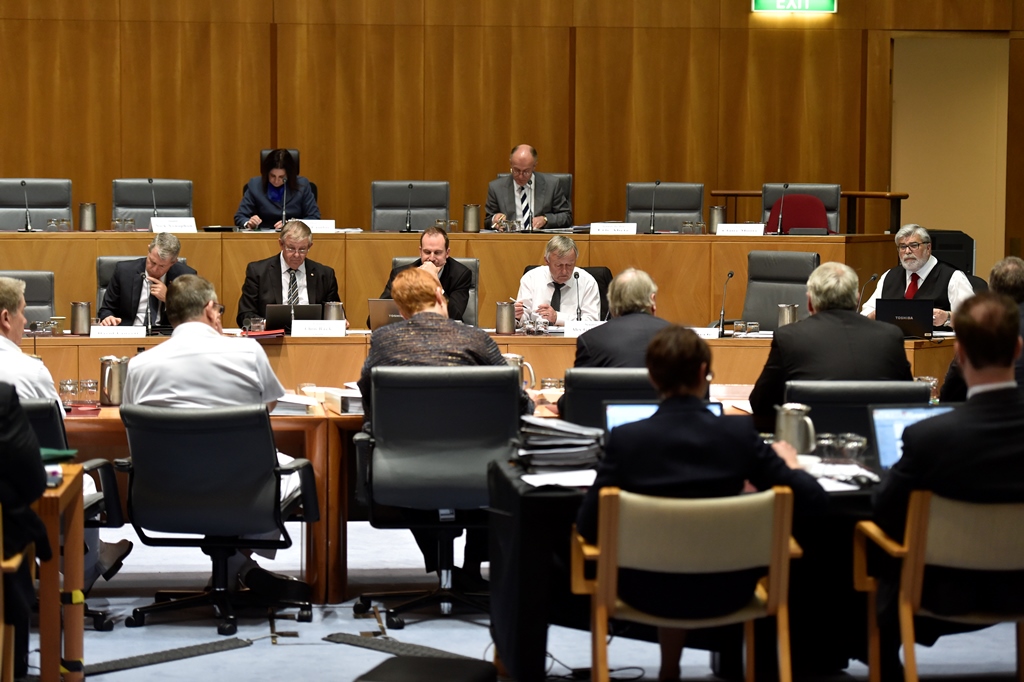 A Senate estimates committee hearing at Australian Parliament House. People are listening to a question being asked.