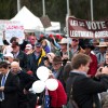 Slide 4: This photo shows a large group of people standing outside with protest signs, such as 'let us vote for a legitimate government'.
