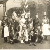Slide 1: Black and white photo showing 2 rows of children wearing costumes in Melbourne in 1901. They are holding flags and banners.