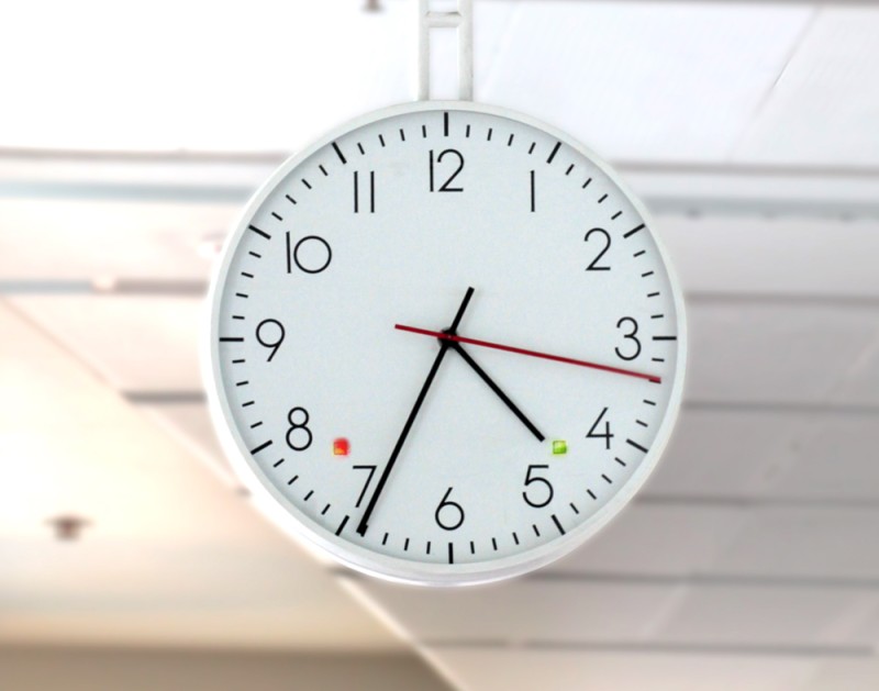 Clock at Parliament House with red Senate and green House of Representatives lights showing.