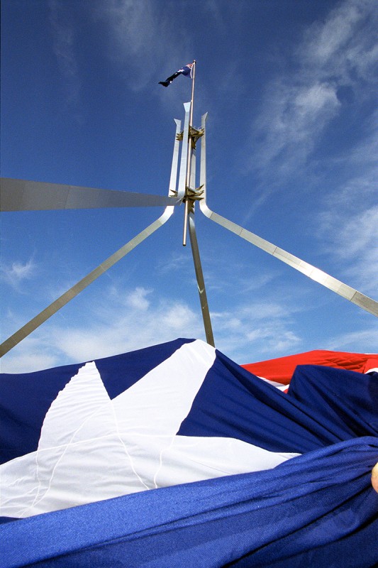 Flagmast on top of Parliament House with a second Australian flag in the foreground.