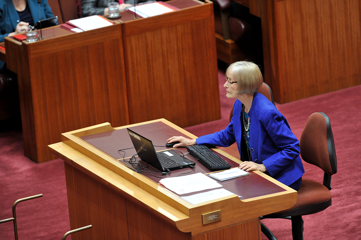 A female Hansard editor in the Senate sits at a desk and works on a computer.