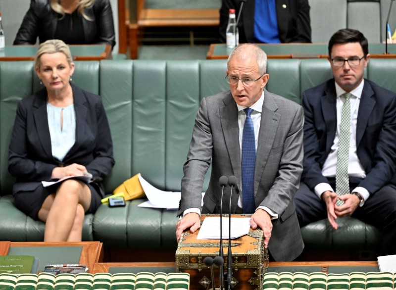 A man in a grey suit is  speaking from the Despatch Box in the House of Representatives.