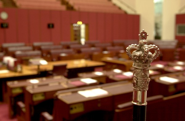 The silver crown of the Black Rod with the red Senate in the background.