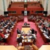 Slide 1: The red Senate chamber. There are people sitting in seats which are arranged in a U-shape around a large central table. 