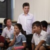 Slide 1: This image shows a group of students in a classroom. One is standing.