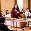 Slide 2: Students in the Education Centre at Parliament House. A student is standing and speaking at a table with boxes and books on it.